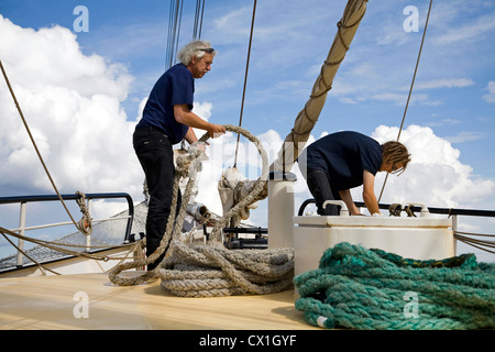 Sailor hawser manipolazione a bordo delle Tall Ship / barquentine Antigua Sailing con i turisti verso le isole Svalbard, Spitsbergen, Norw Foto Stock