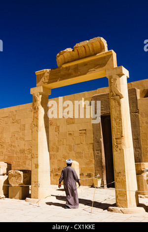 Uomo egiziano all'ingresso della cappella di Hathor presso il Tempio di Hatshepsut, Luxor, West Bank, Egitto Foto Stock