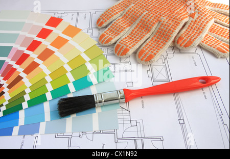 Una guida a colori, un pennello e guanti con la pianta di casa sullo sfondo Foto Stock