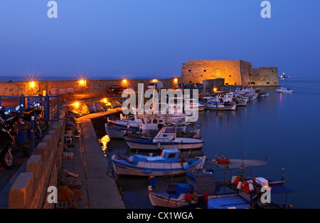 Vista notturna del vecchio porto veneziano di Heraklion, Creta, Grecia. Sullo sfondo si può vedere il castello Kule. Creta, Grecia. Foto Stock