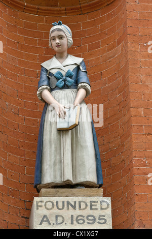 Statua di ceramica di una ragazza della scuola al di fuori di St John's school a Wapping London Foto Stock