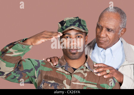 Ritratto di US Marine Corps soldato con padre salutando su sfondo marrone Foto Stock