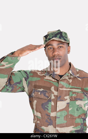 Ritratto di un afro-americano US Marine Corps soldato salutando su sfondo grigio Foto Stock