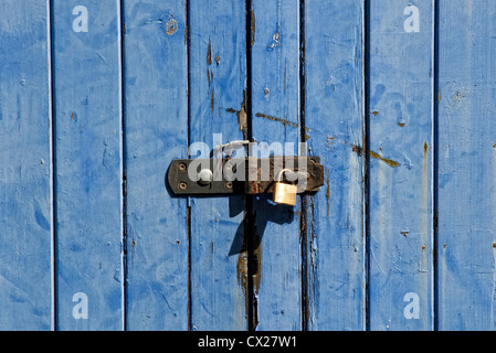 Vecchio weathered blue porte in legno con un lucchetto Foto Stock