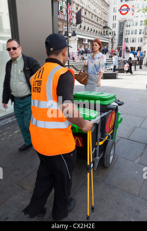 McDonalds pattuglia di lettiera operativa con bin in The Strand Londra Foto Stock