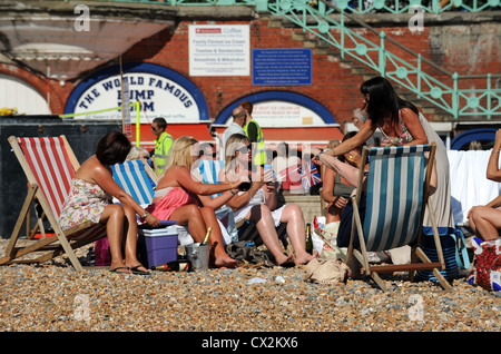 Gruppo di donne che prendono il sole in sdraio sulla spiaggia a. Brighton Regno Unito Foto Stock