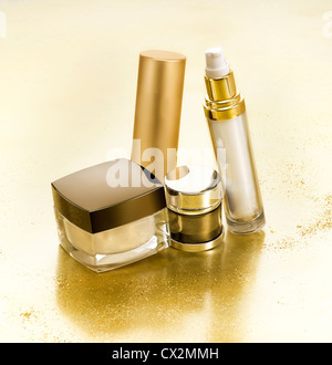 Cosmetici in ambiente di lusso con piccole pepite d'oro Foto Stock