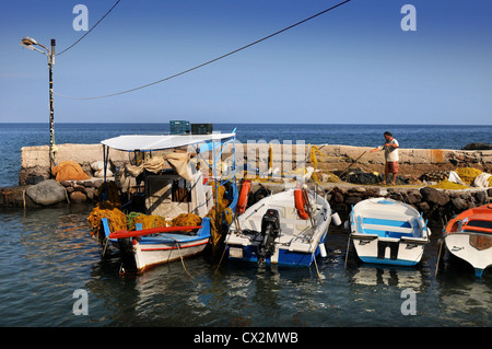 Un pescatore che tende a le sue reti sul porto di Portes sull isola di Aegina Grecia Foto Stock