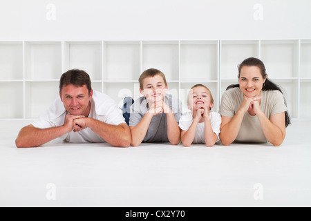 Dolce famiglia giovane divertirsi sul pavimento nella loro casa Foto Stock