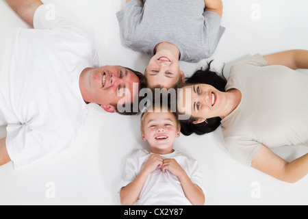 La famiglia felice di quattro sdraiato sul pavimento Foto Stock