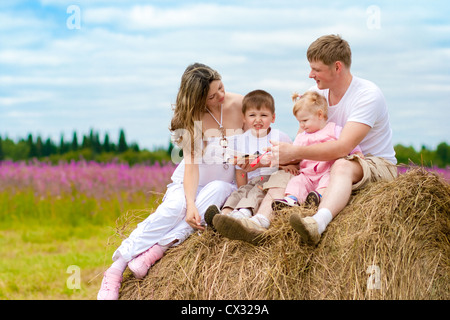 La famiglia felice varo toy modello di aeromobile seduti sul pagliaio insieme Foto Stock