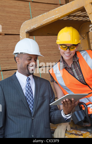 African American businessman e femmina operaio industriale guardando un tablet PC Foto Stock