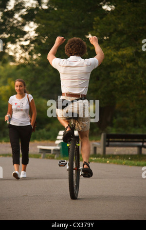 Giovane uomo a cavallo di un monociclo nel parco. Foto Stock