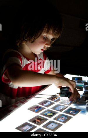 Ragazzo che guarda a 35mm scorre sulla scatola di luce. Foto Stock