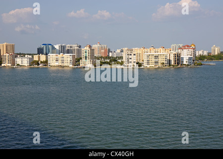 Vista degli edifici sul bordo di Sarasota Bay, Sarasota, Florida dall'acqua con cielo blu e nuvole bianche. Foto Stock