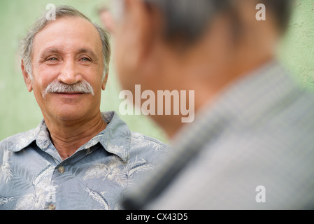 Pensionati anziani e amicizia, due uomini anziani incontrare e parlare nel parco della città Foto Stock
