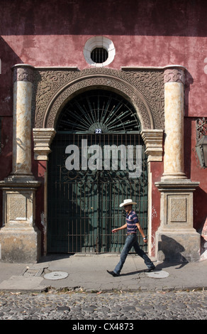 Uomo che cammina passato porta ornati in La [UNESCO World Heritage Site] di Antigua Guatemala America Centrale Foto Stock