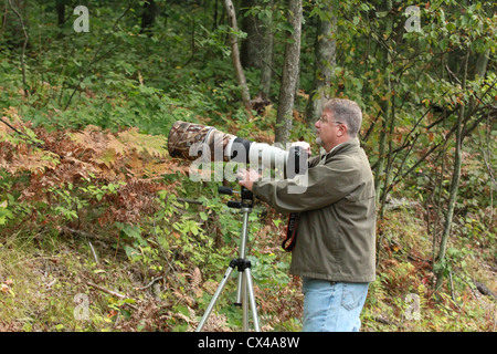 Un fotografo professionista si prepara a prendere una foto con un teleobiettivo. Foto Stock