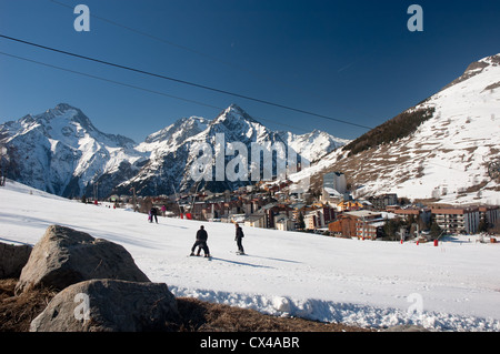 Pendenza sci con gli sciatori circondata da montagne di Les 2 Alpes, sulle Alpi francesi Foto Stock