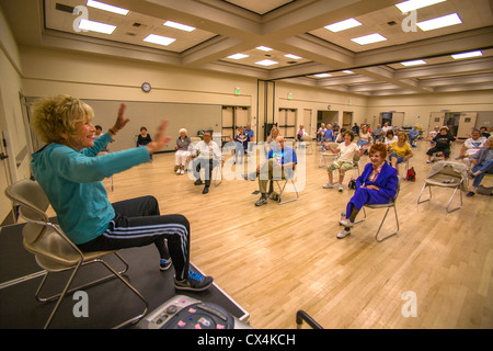Un istruttore conduce un esercizio per la classe senior di donne e uomini al lavoro in un centro di senior in Tustin, CA. Foto Stock