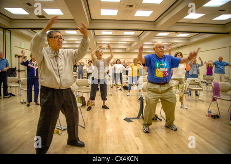 Senior uomini e donne lavorano fuori durante un esercizio di classe a un senior centre di Tustin, CA. Foto Stock