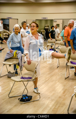 Senior uomini e donne lavorano fuori durante una sedia esercizio di classe a un senior centre di Tustin, CA. Foto Stock