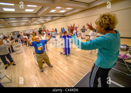 Un istruttore conduce un esercizio per la classe senior uomini e donne a un senior centre di Tustin, CA. Foto Stock