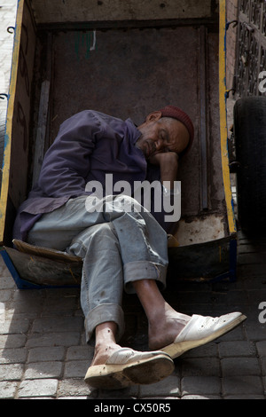 L'uomo addormentato nella sua carriola nei souks, antica medina, Marrakech, Marocco, Africa del nord Foto Stock