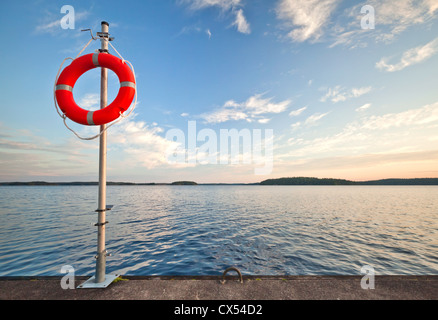 Attrezzature di sicurezza. Rosso brillante salvagente sicuro sul molo Foto Stock