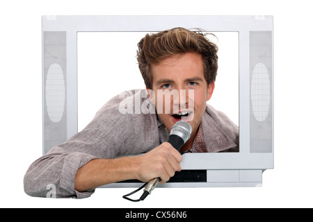 Uomo cantano all'interno del televisore Foto Stock