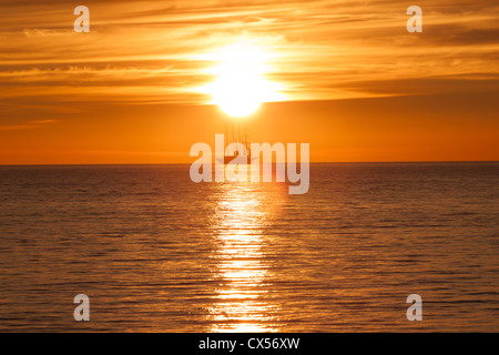 Nave a vela silhouette in mare. Sun sunset on Fire Foto Stock