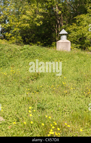 Albero di ventilazione camino per un sotterraneo al di sotto del suolo abitazione contrasta con prato circostante di pascoli e boschi Foto Stock