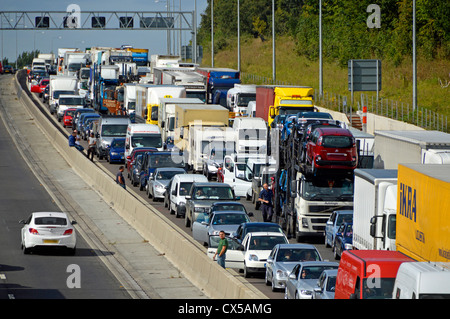 Vista dall'alto del traffico stazionario intrappolato e bloccato su quattro corsie dell'autostrada M25 alcuni conducenti fuori dai loro veicoli Essex Inghilterra UK Foto Stock