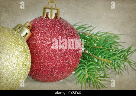 Rosso e oro baubles di Natale con pine /abete rosso di ramo di albero su sfondo rustico Foto Stock