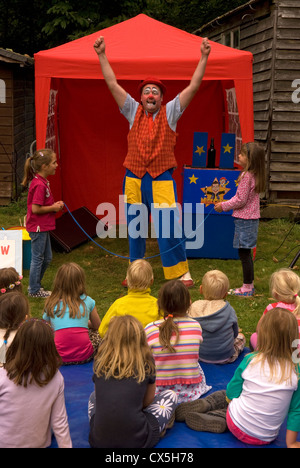 Clown divertente i ragazzi ad un outdoor per bambini giornata di divertimento, Liphook, Hampshire, Regno Unito. Foto Stock