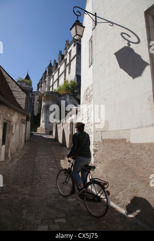 Una vista di uno dei tanti vicoli in ciottoli nell'antica città reale di Loches con una donna sulla sua bicicletta immettendo il colpo fro Foto Stock