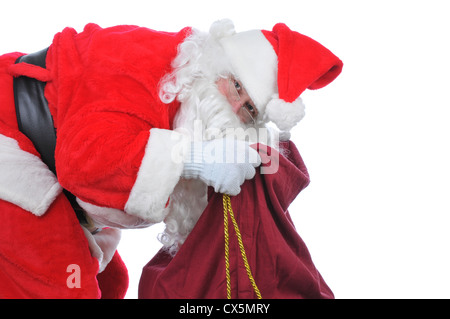 Santa ripiegate e cercando nella sua borsa per più di giocattoli isolato su bianco Foto Stock