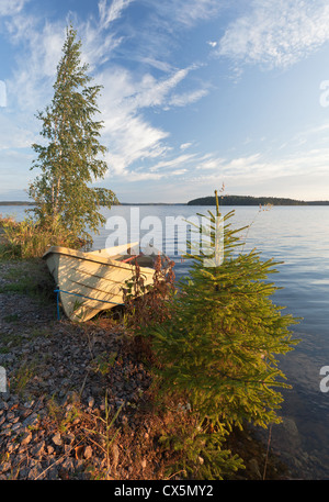 Paesaggio di mattina con la vecchia barca a remi e alberi sulla costa del Lago Saimaa, Finlandia Foto Stock