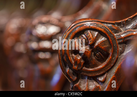 Facce scolpite sui braccioli del tredicesimo secolo inizio inglese coro in Hexham Abbey, Northumberland, Inghilterra Foto Stock