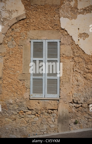 Una tradizionale finestra ritagliata in Maiorca con un vecchio muro incrinato esposizione di mattoni Foto Stock