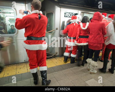 Un babbo natale fotografie la metropolitana durante la Santa Con, annualmente un pub crawl con migliaia vestiti da Babbo Natale. Foto Stock
