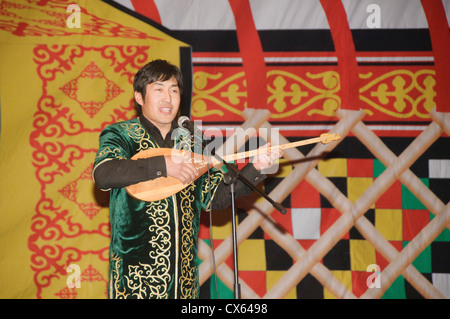 Musicista kazaka riproduzione di un tradizionale dombra strumento a corda in Bayan-Ölgii in Mongolia occidentale Foto Stock