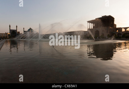 Fontana con vista l'Imam moschea e l'Ali Qapu palace sulla Naqsh-e JAHAN Piazza o Imam square, a Isfahan, Iran Foto Stock
