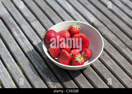 Una tazza di fragole su un tavolo per esterno Foto Stock