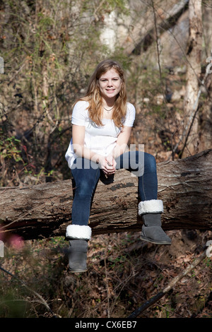 Ragazza seduta sul tronco di albero in Mooresville, North Carolina, STATI UNITI D'AMERICA Foto Stock