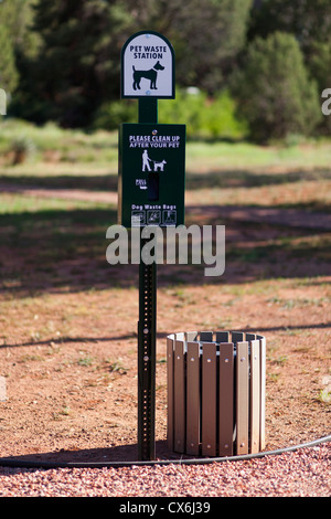 Un segno e un bidone per rifiuti di PET in un parco Foto Stock
