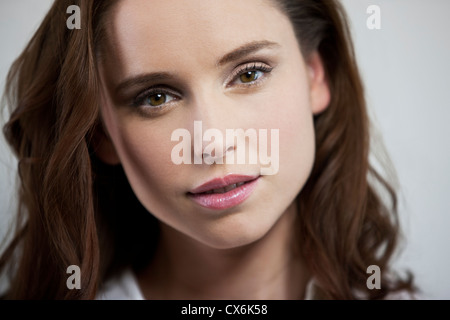 Una giovane donna che guarda alla telecamera, sorridente Foto Stock