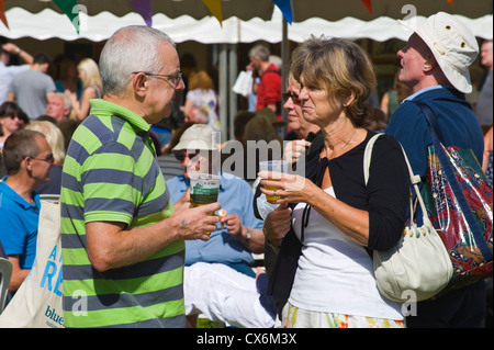 I visitatori di bere alcolici al di fuori nel sole a Ludlow Food Festival 2012 Ludlow Shropshire England Regno Unito Foto Stock