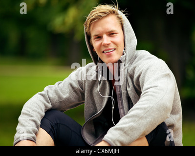 Bel ragazzo cerca rilassato e godendo di ascolto di MP3 Foto Stock