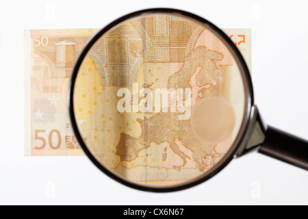 Una lente di ingrandimento Ingrandimento di una cinquantina di banconote in euro Foto Stock